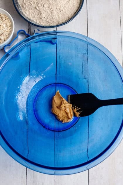 Adding peanut butter to a mixing bowl