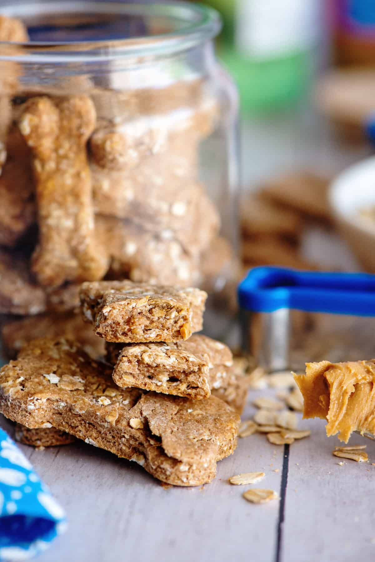 A stack of doggie biscuits in front of a jar