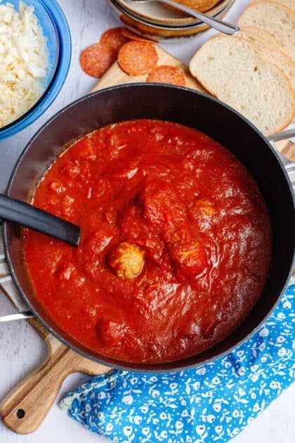 Simmering pizza soup with meatballs