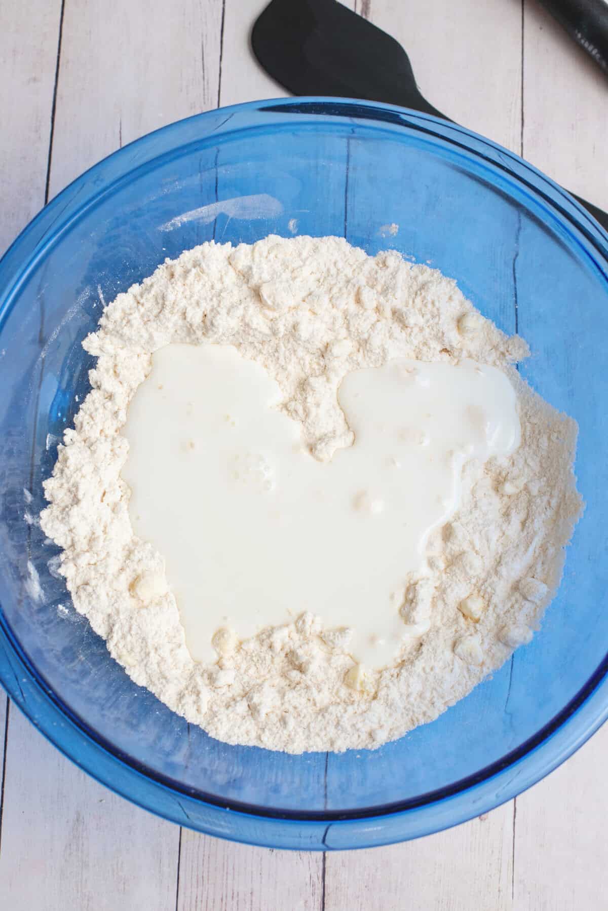 Adding the buttermilk to the cathead biscuits mix
