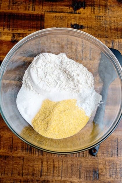 Cornmeal, flour, sugar, baking powder, and salt in a glass mixing bowl.
