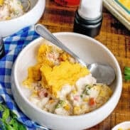 A bowl of cornbread chicken pot pie with a spoon.