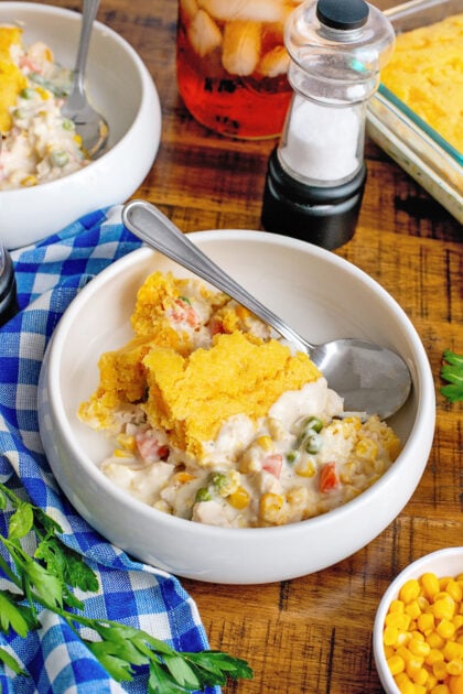 A bowl of cornbread chicken pot pie with a spoon.