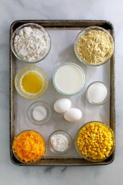 Cornbread topping ingredients for chicken pot pie include cornmeal, baking powder, baking soda, shredded cheddar cheese, whole kernel corn, butter, salt, eggs, and milk.