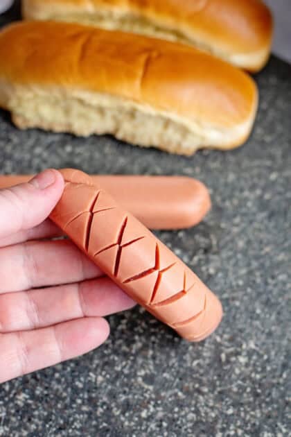 Showing the cuts on a scored hot dog
