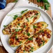 A plate with 3 zucchini stuffed boats
