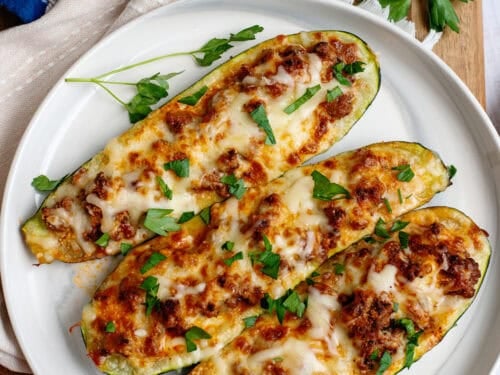 A plate with 3 zucchini stuffed boats