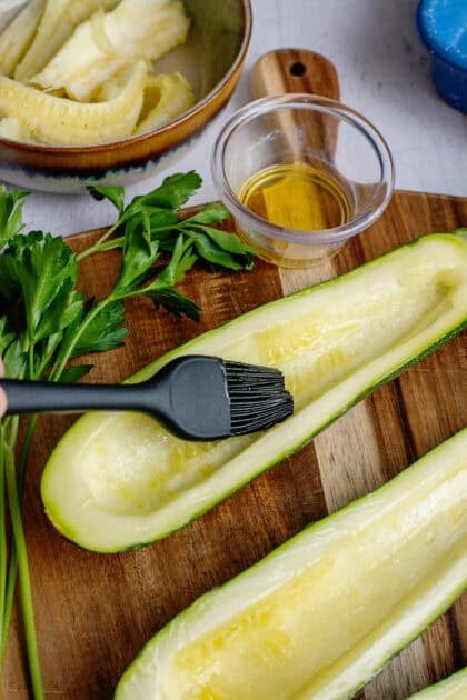 Brushing the zucchini halves with olive oil