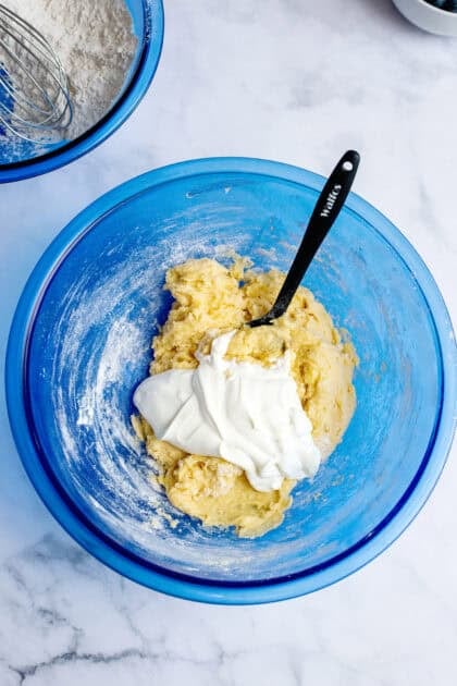 Adding sour cream to the mixing bowl of ingredients