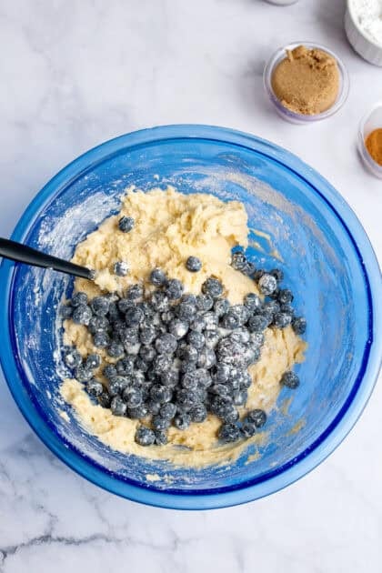 Blueberries in a bowl of mixed dry and wet ingredients for the coffee cake