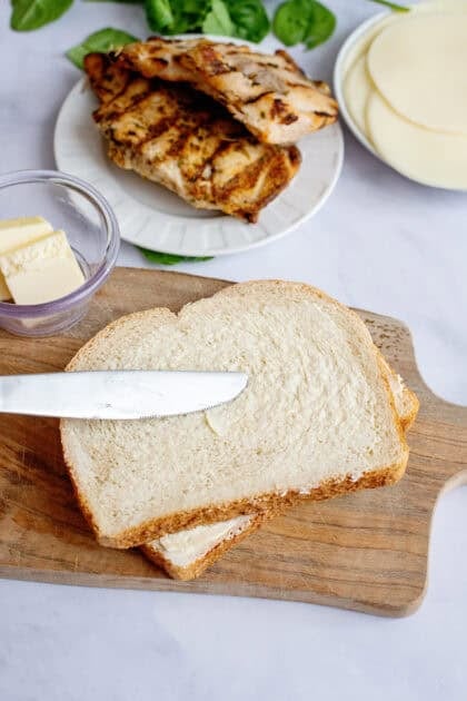 Spreading softened butter on a slice of bread