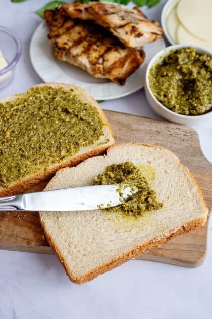 Spreading pesto on a slice of bread