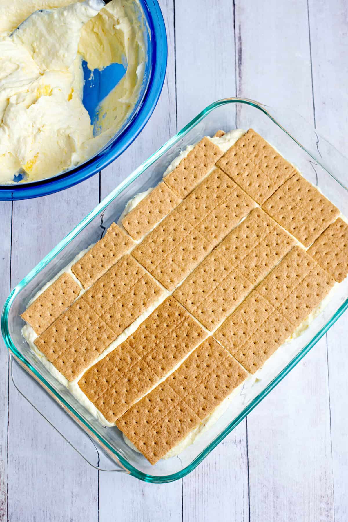 Adding a second graham cracker base over the vanilla pudding mix