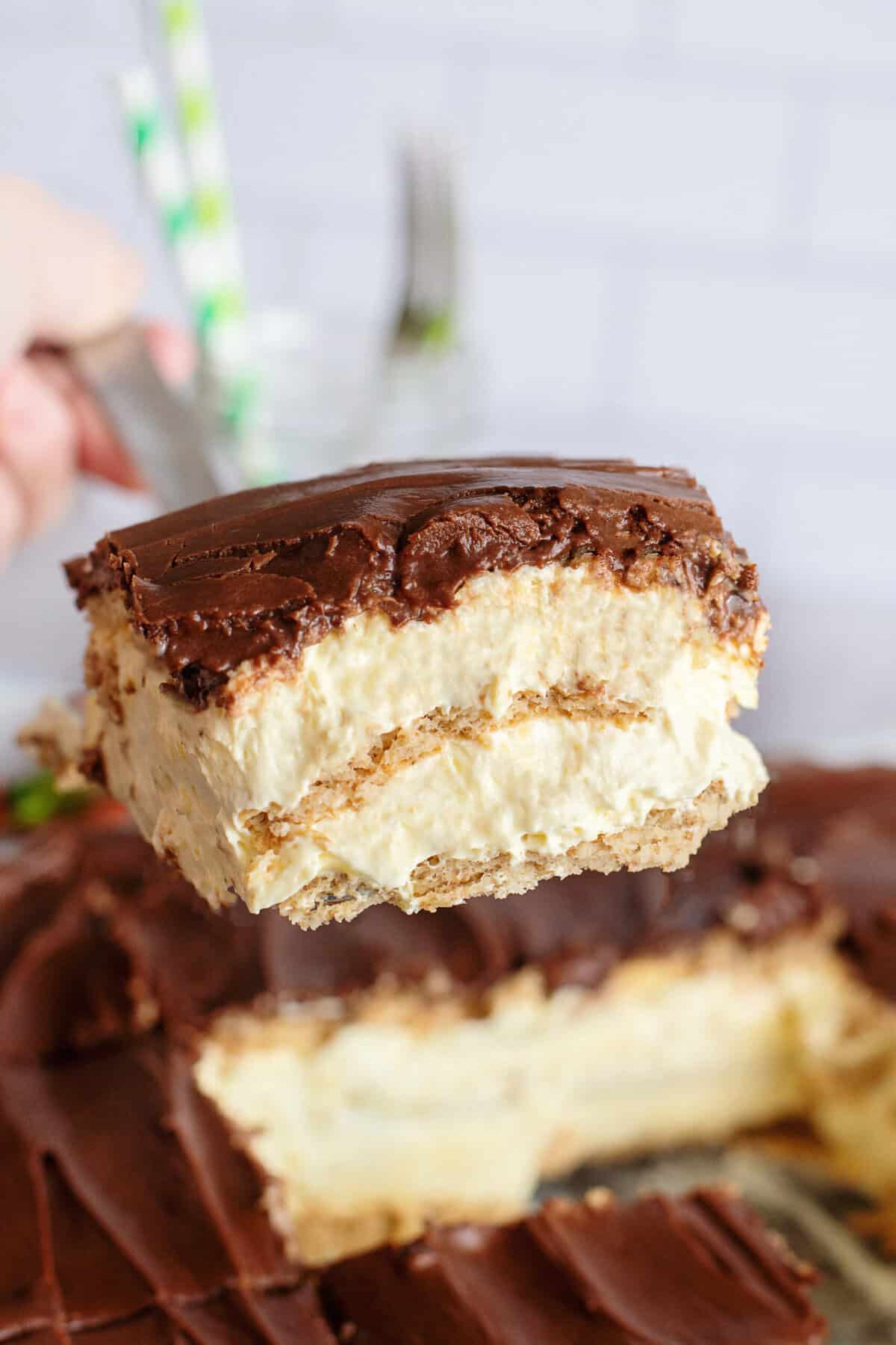 A slice of chocolate eclair icebox cake resting on a spatula.