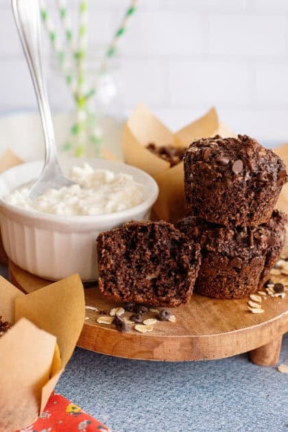 A tray with chocolate cottage cheese muffins next to a bowl of cottage cheese