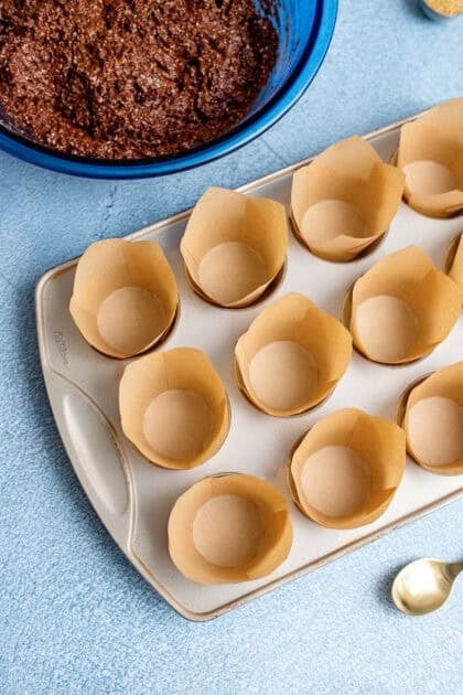 Lining a 12-muffin baking pan with parchment paper