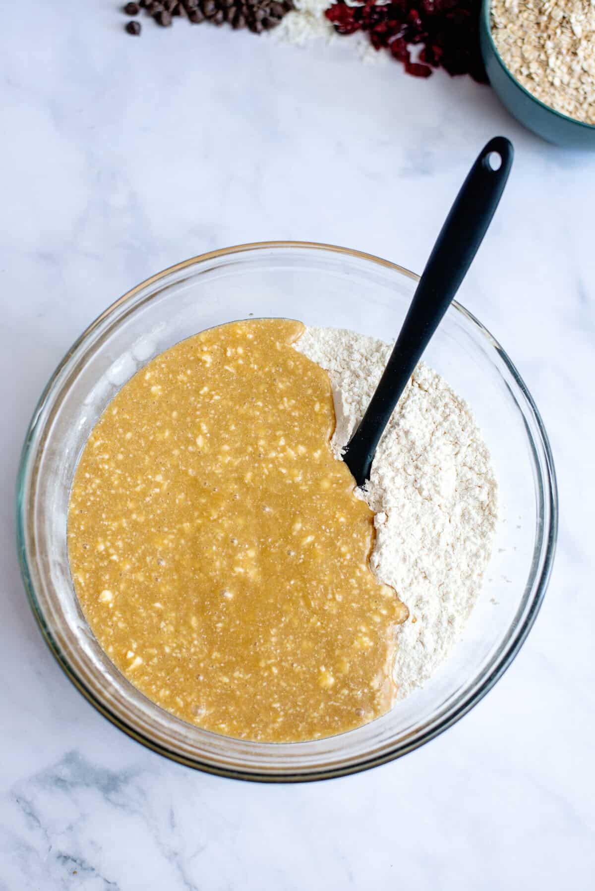 Combining the dry and wet ingredients for loaded chocolate chip oatmeal cookies