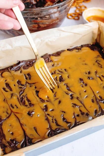 Adding caramel sauce to the brownie spread layer