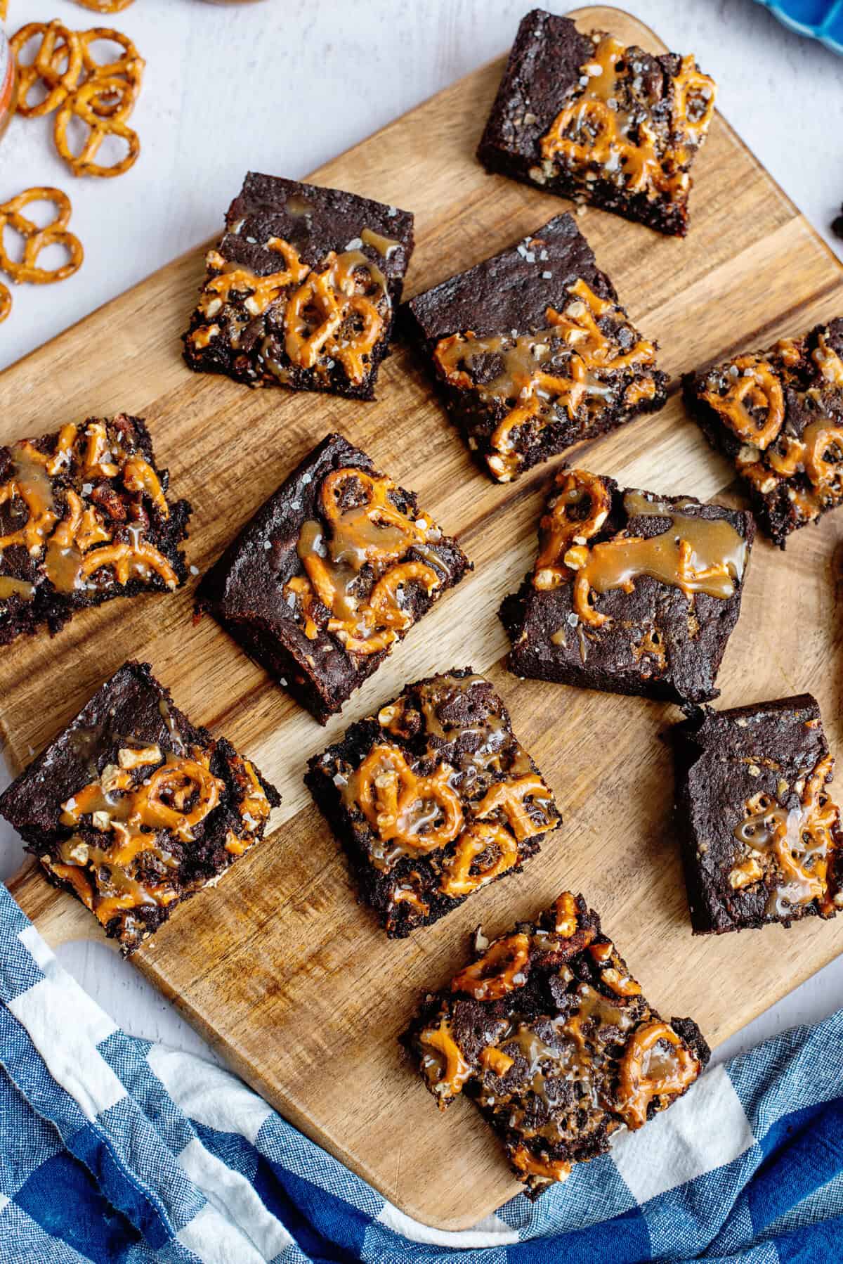 Salted caramel pretzel brownie slices on a cutting board