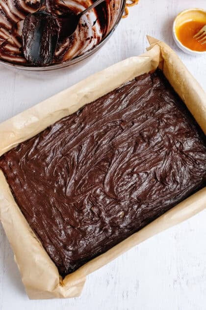 brownie batter spread evenly in a prepared pan