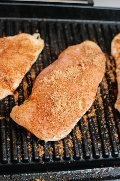 Placing the seasoned chicken on a grill