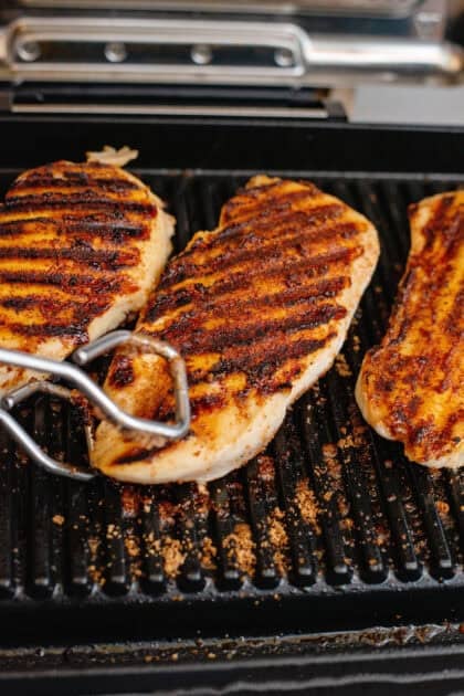 Flipping the chicken on the grill with tongs