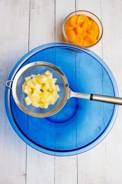 Draining the chopped pineapple