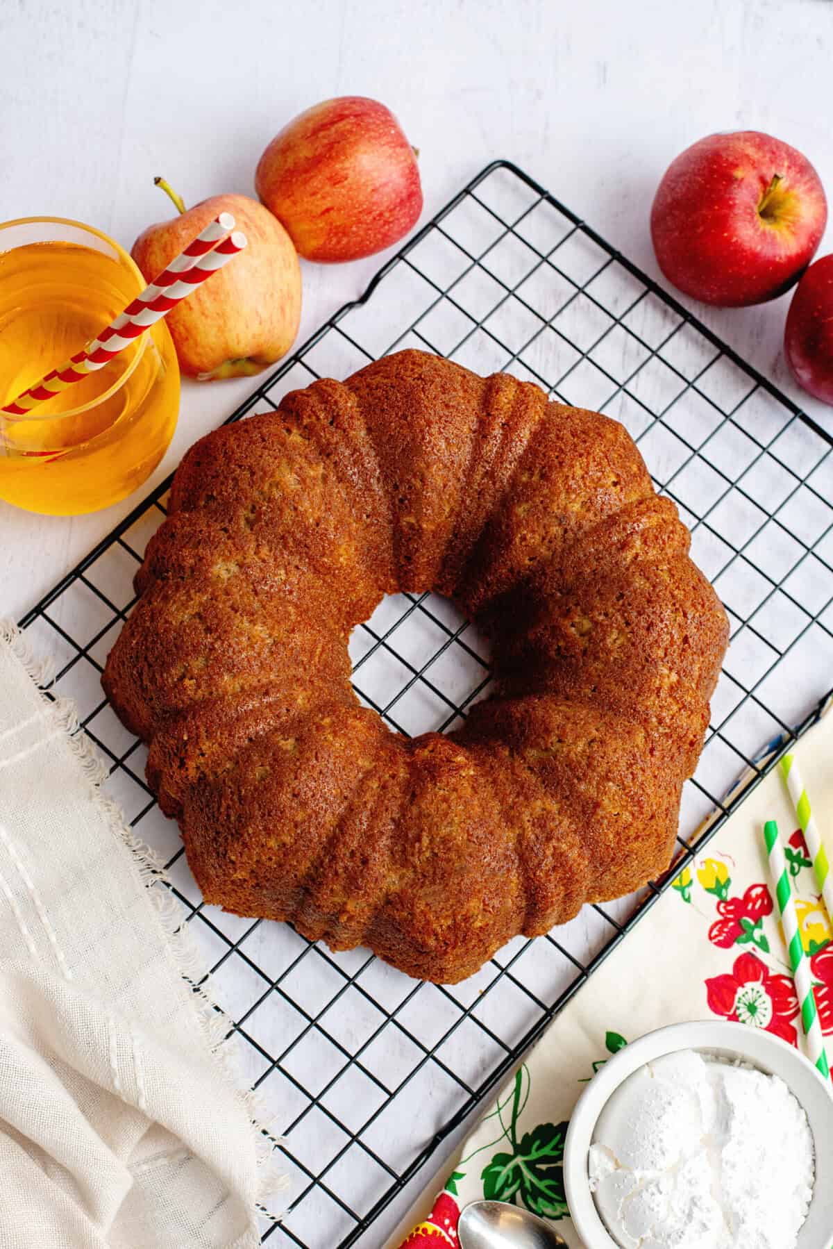 Apple cider bundt cake on a cooling rack.