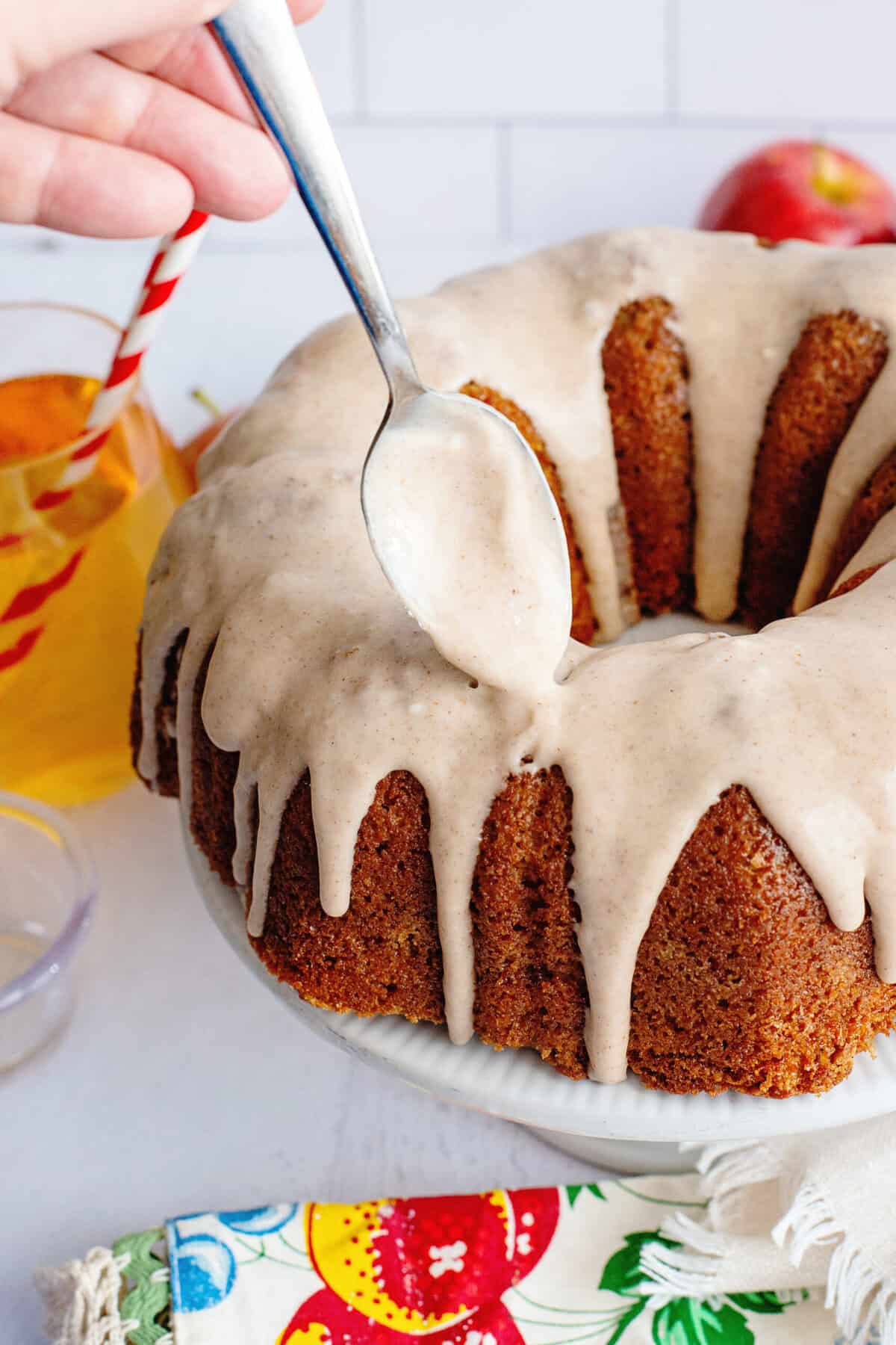 Adding the glaze to an apple cider bundt cake.