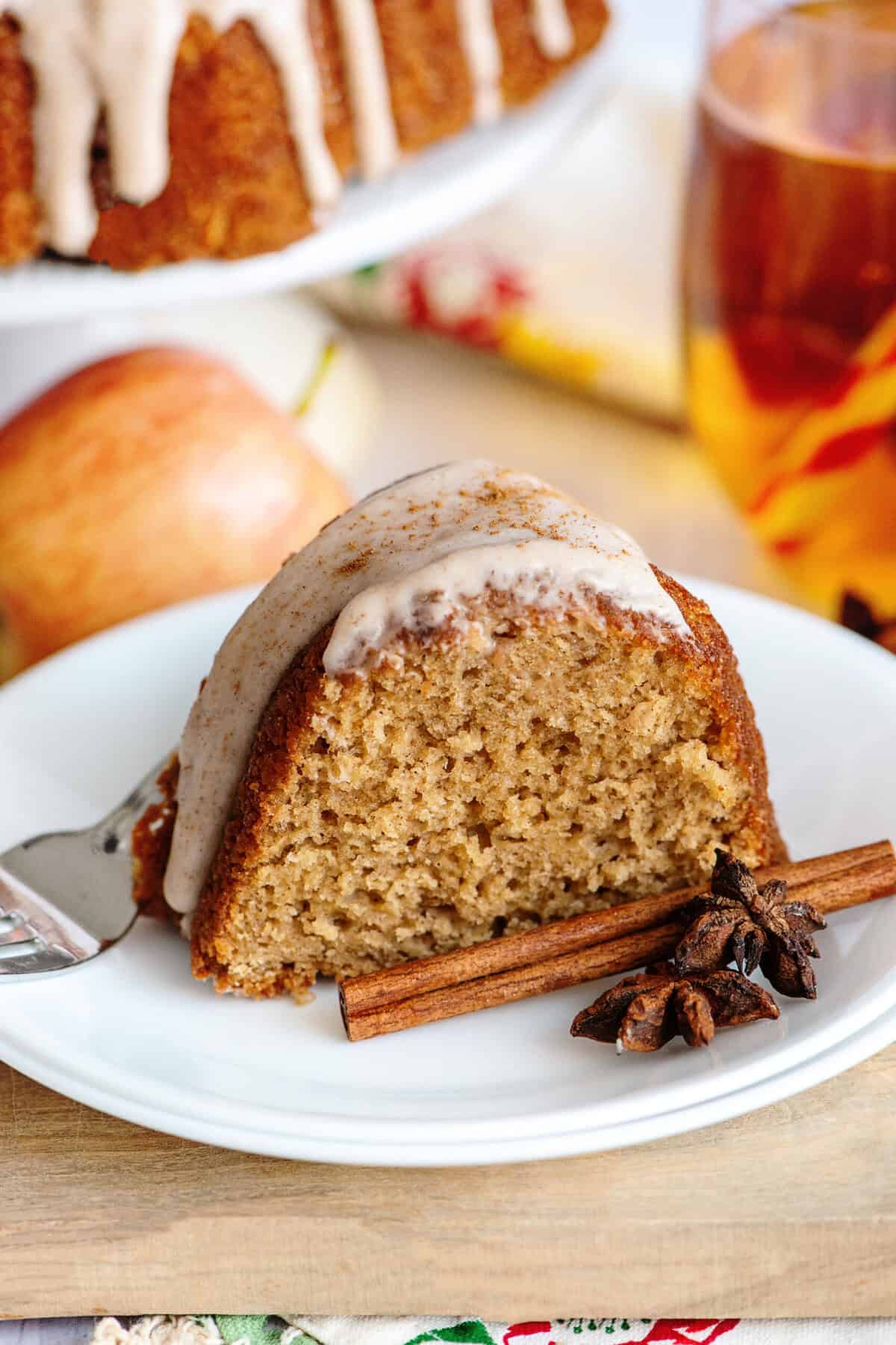 A slice of apple cider bundt cake on a white plate.