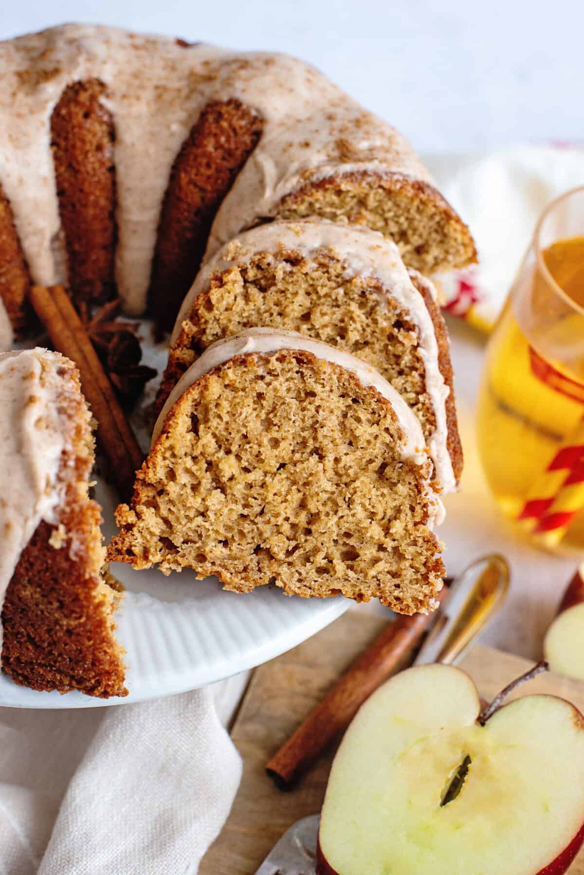 Sliced apple cider bundt cake on a cake stand.