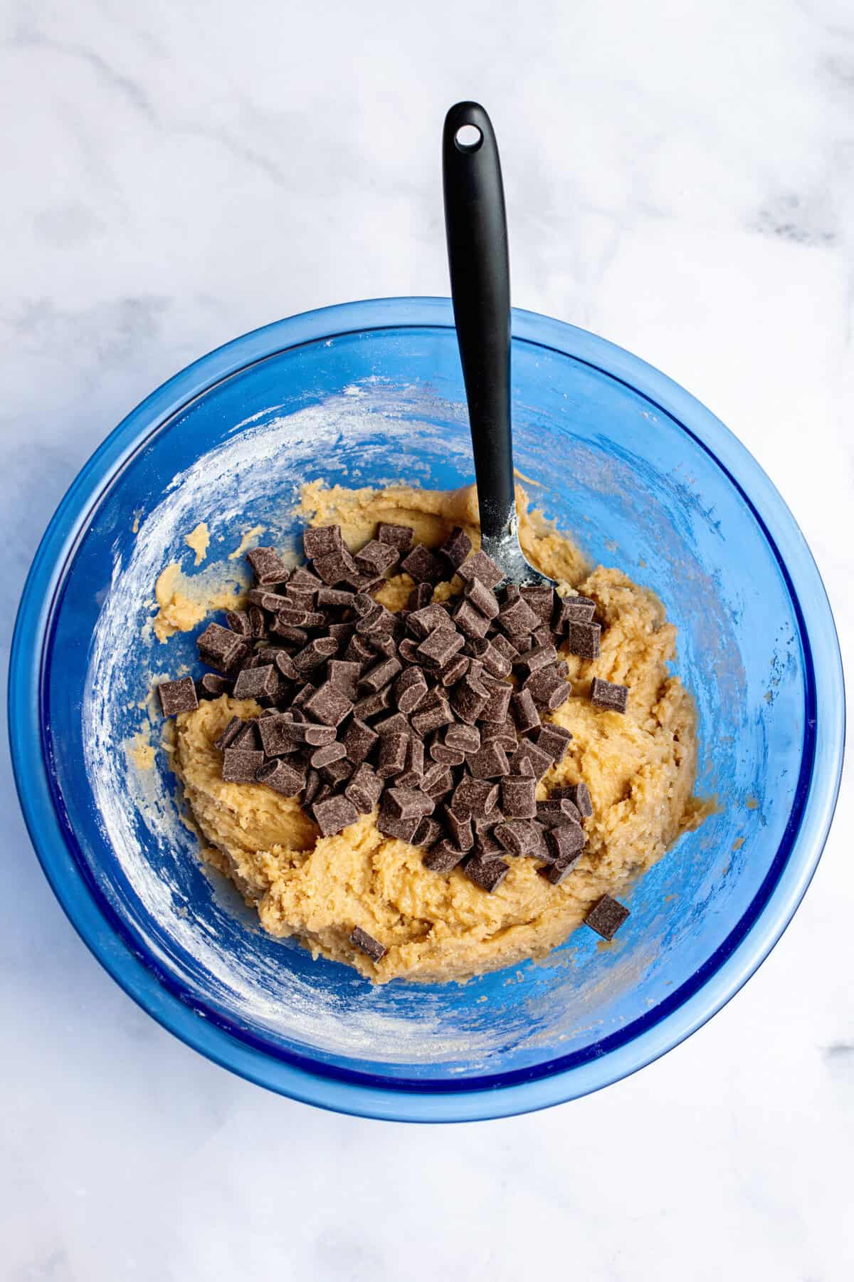 Folding chocolate chips into a bowl of dough.
