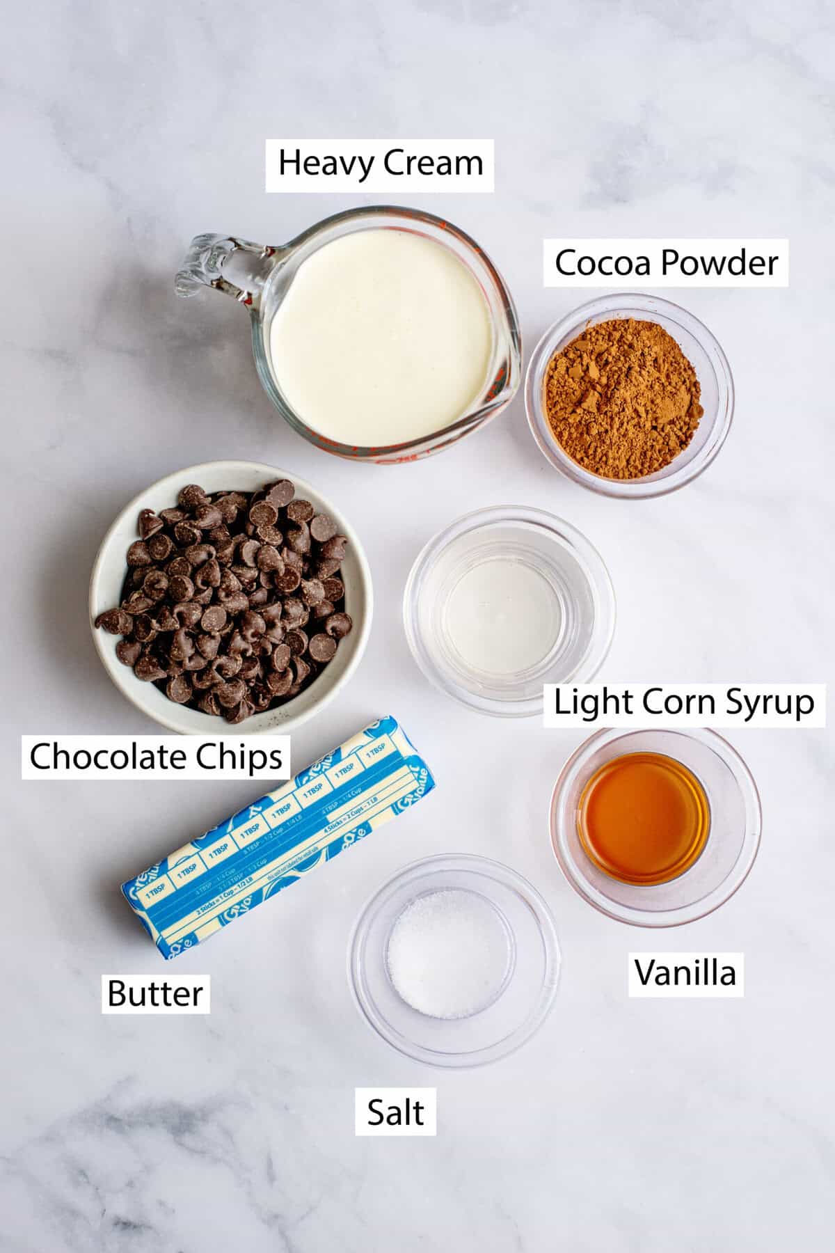 Ingredients for homemade hot fudge, featuring heavy cream, chocolate chips, unsalted butter, light corn syrup, cocoa powder, salt, and vanilla extract.