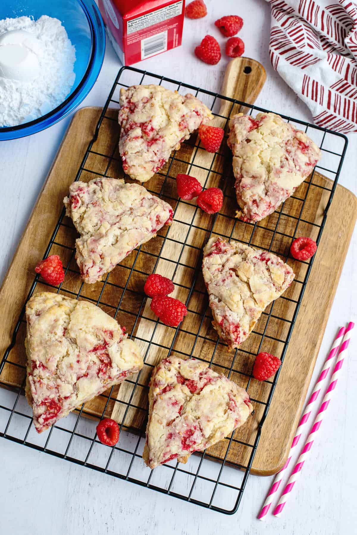 Freshly baked raspberry scones on a cooling rack.