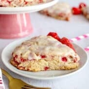Glazed raspberry scone on a white plate.