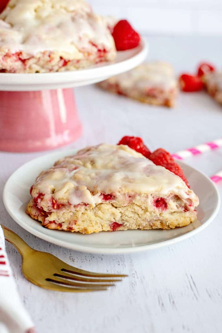 Glazed raspberry scone on a white plate.