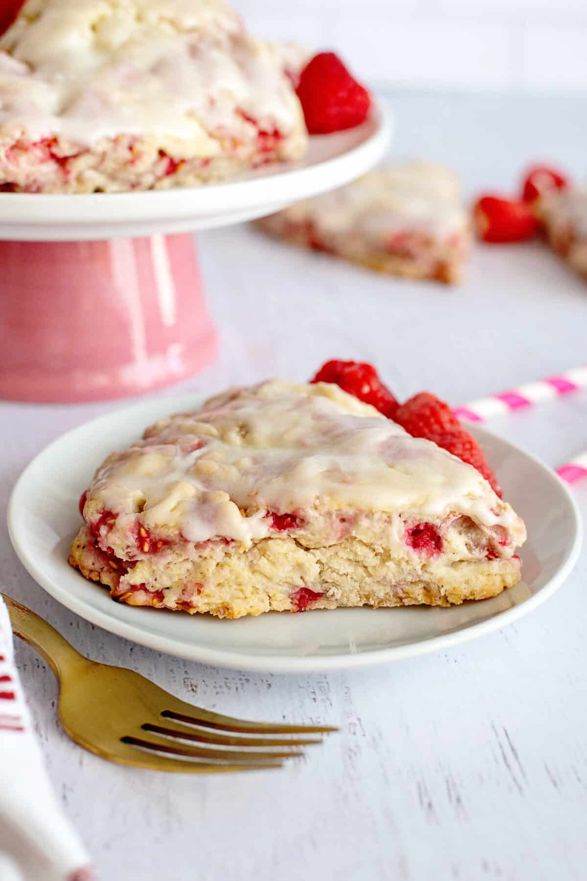 Glazed raspberry scone on a white plate.
