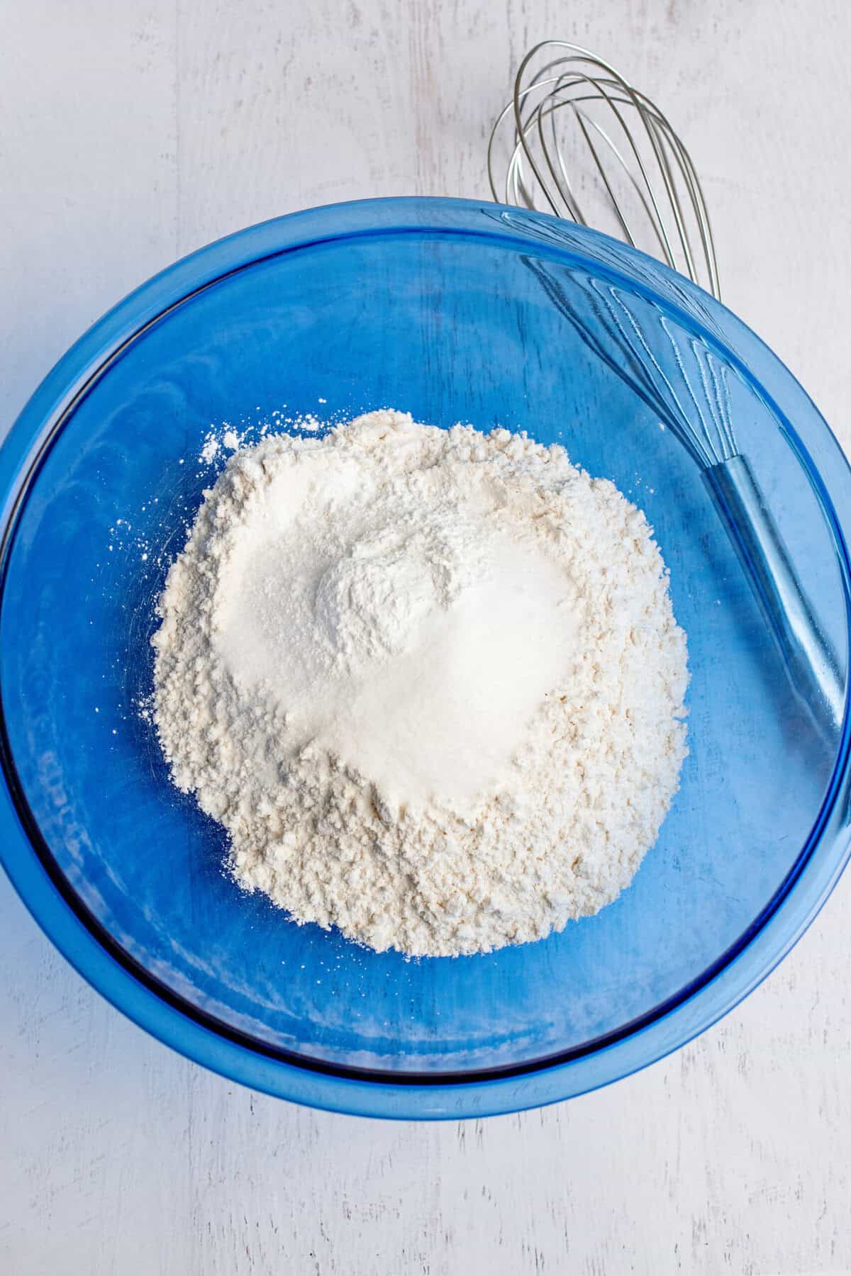 Dry ingredients in a glass blue mixing bowl.