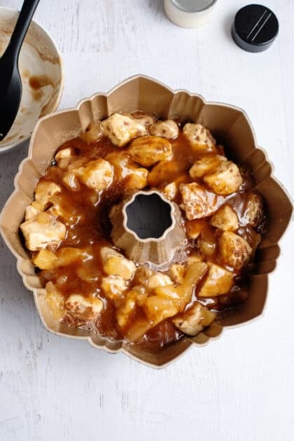 Apple pie cinnamon roll monkey bread in a bundt pan ready to bake.