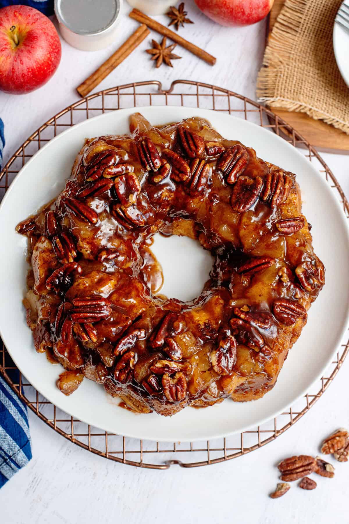 Flipped apple pie cinnamon roll monkey bread on a white plate.