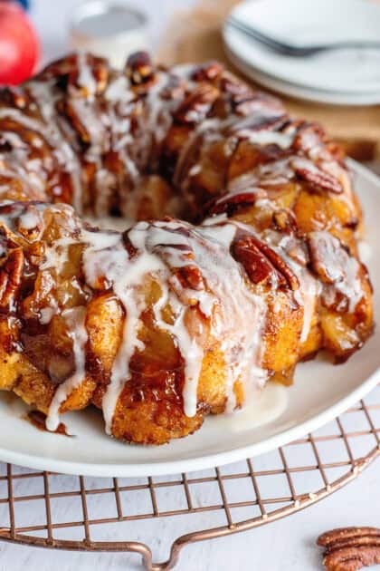 Apple pie cinnamon roll monkey bread on a plate with icing.
