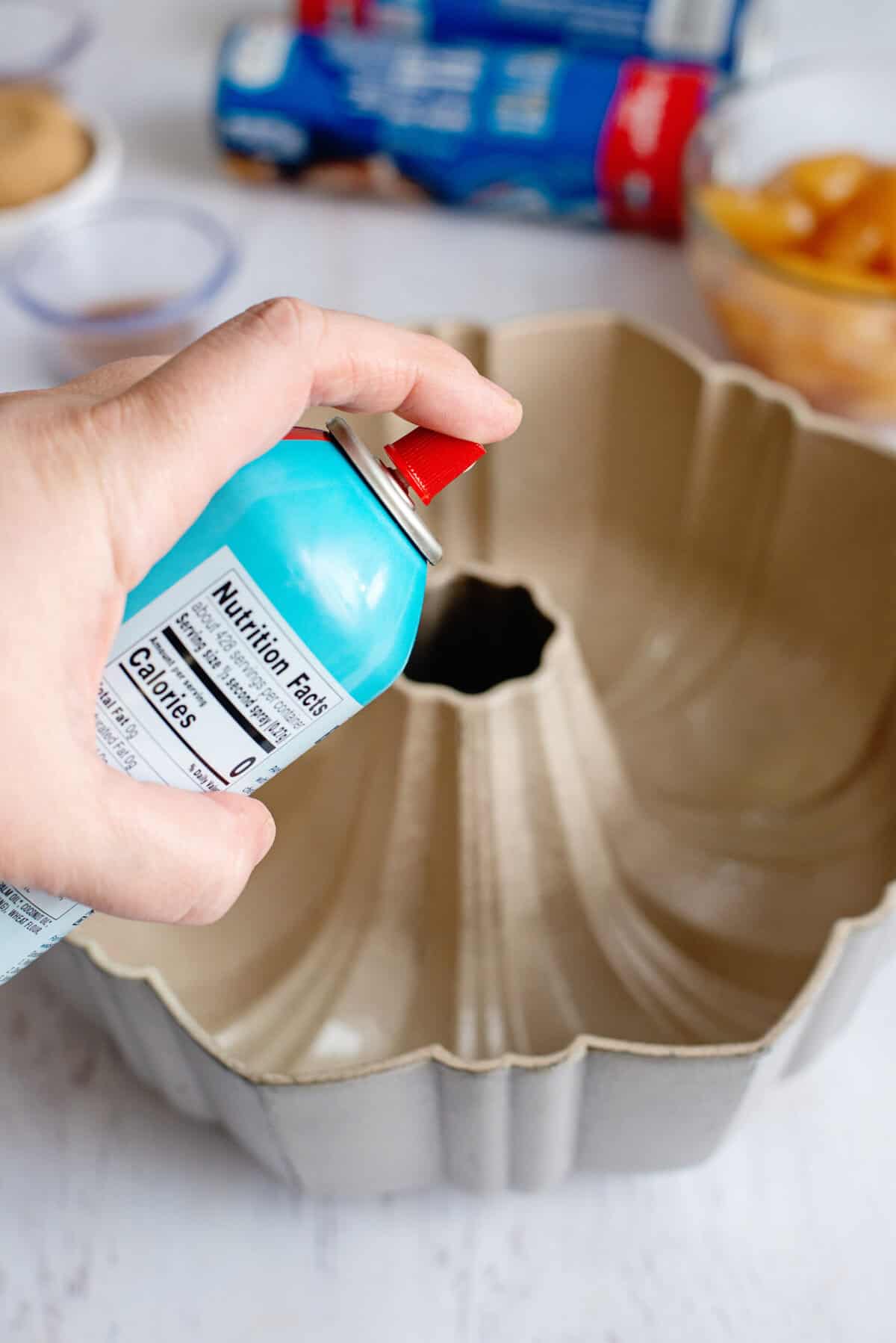 Spraying a bundt cake with cooking spray.