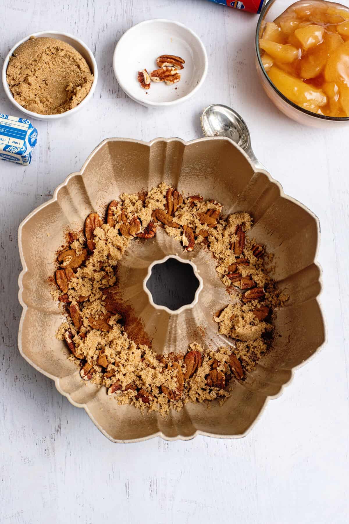 Pecans, brown sugar, and cinnamon at the bottom of a bundt cake pan.