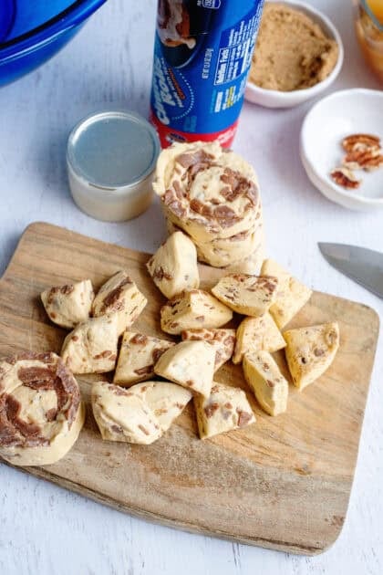 Cinnamon roll pieces on a wooden cutting board.
