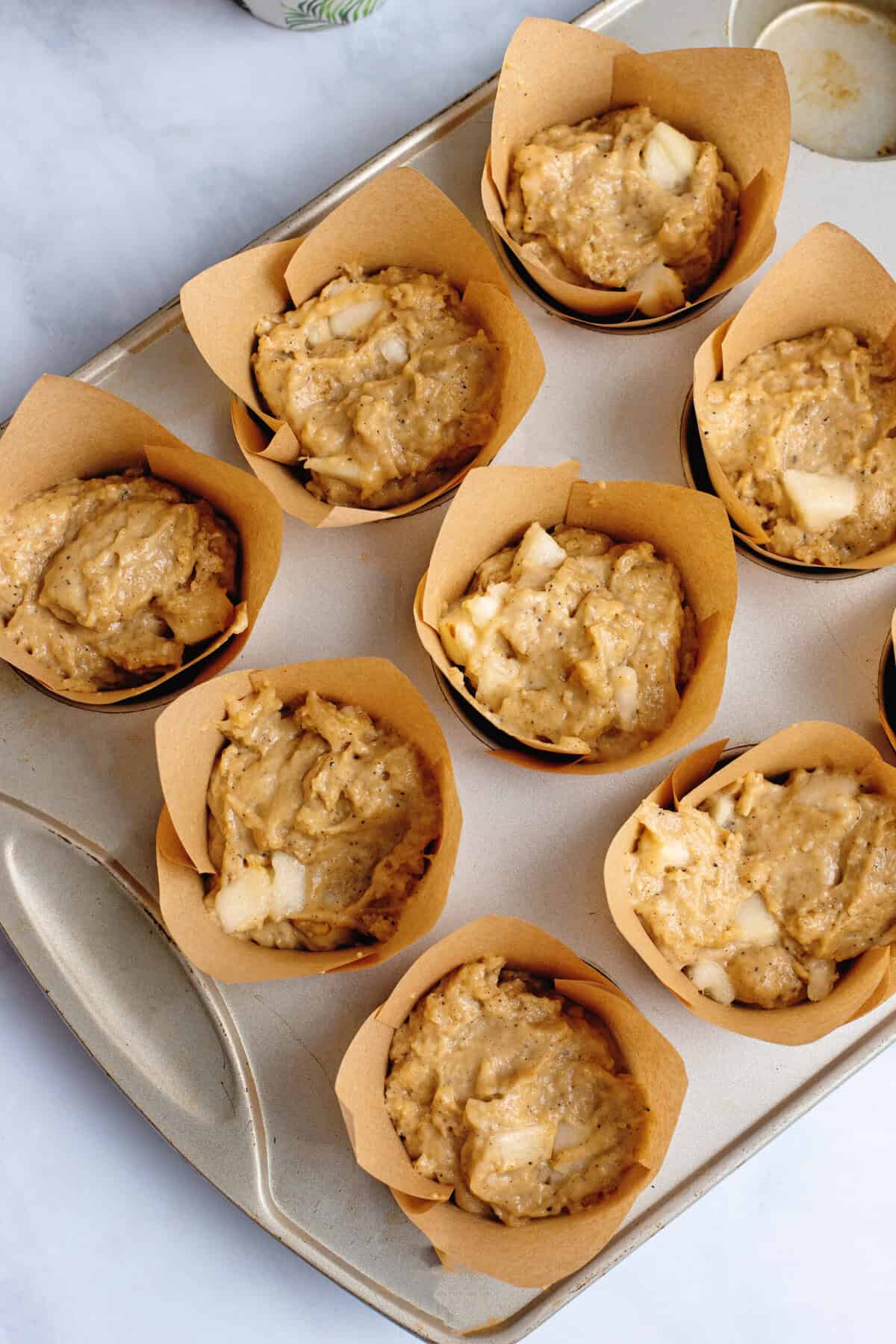 Dough for muffins in a muffin tin.