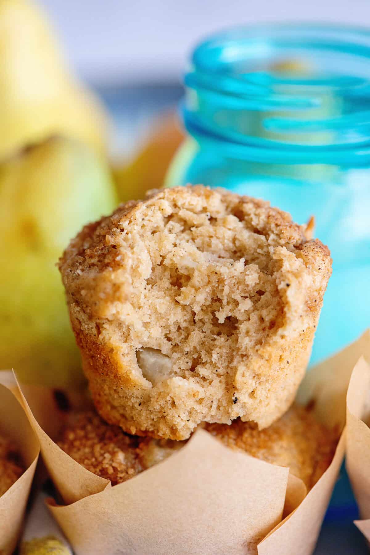 Brown butter pear muffin with a bite taken out of it.