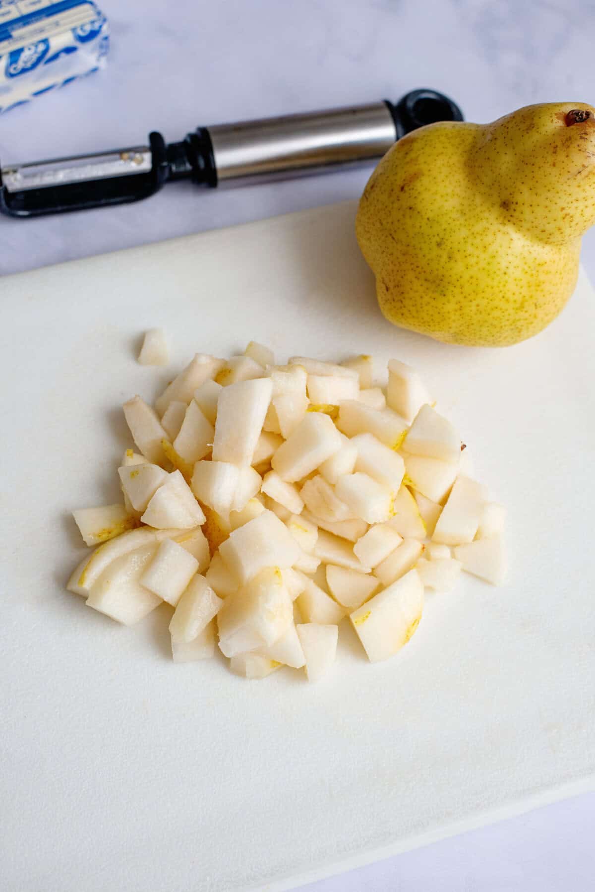 Chopped pears on a white cutting board.