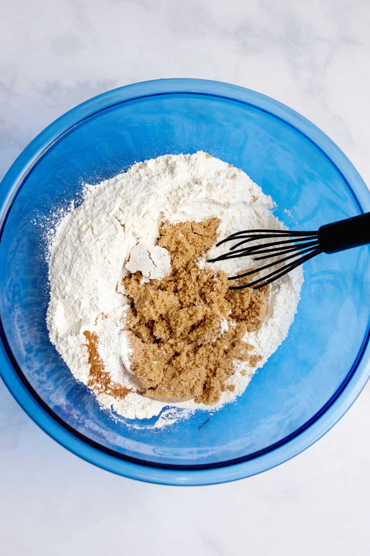 Dry ingredients in a glass blue mixing bowl.