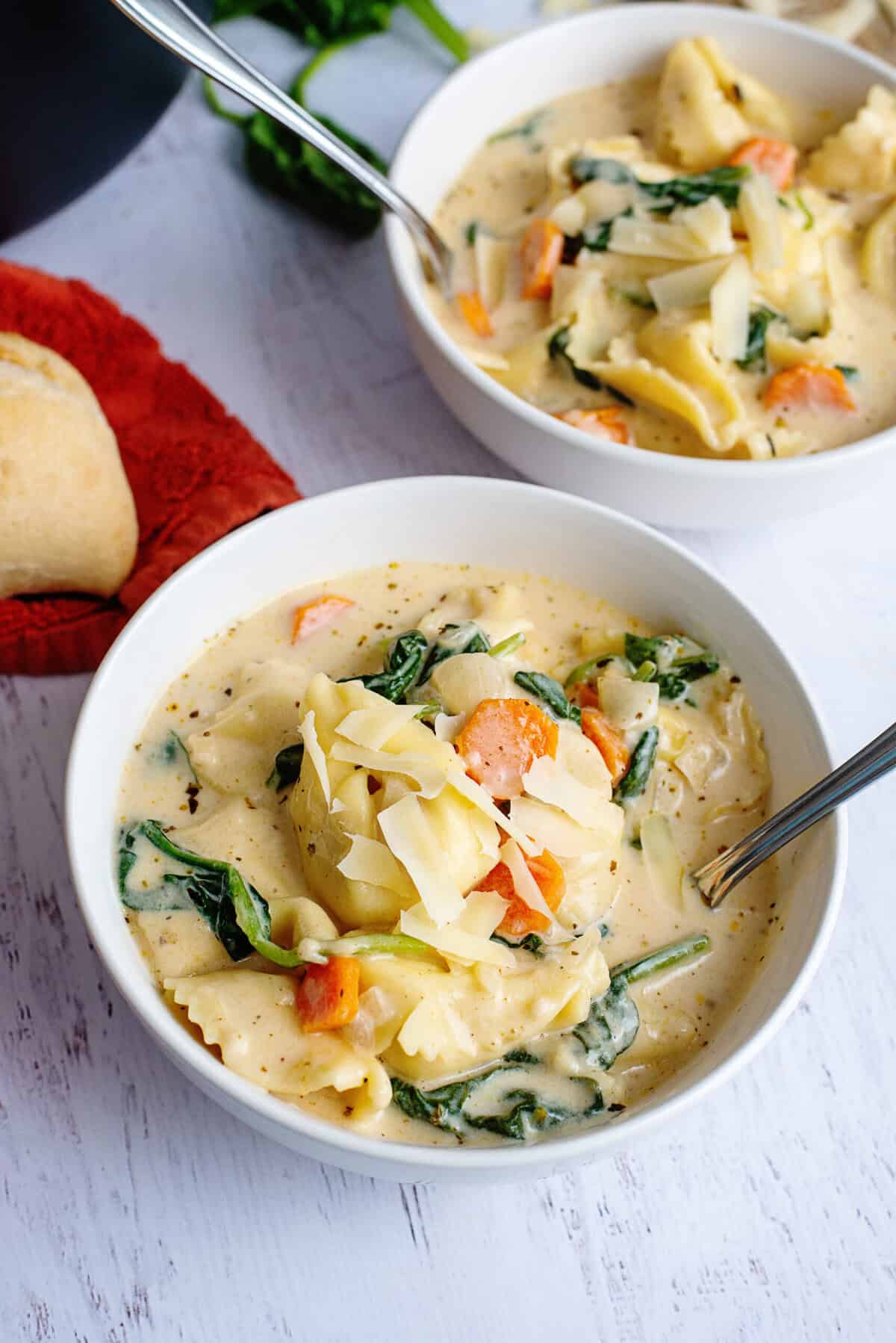 Two bowls of creamy tortellini soup.