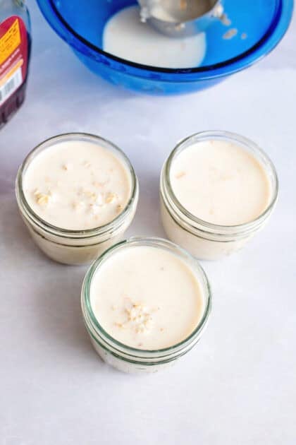 Overnight oats in three mason jars with the lids open.